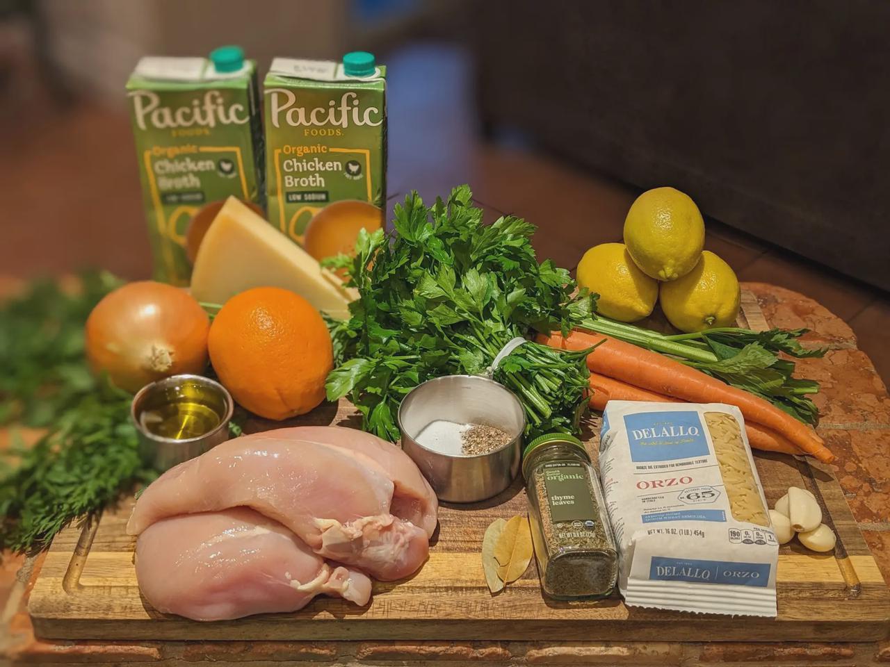 Platter of Citrus Chicken Orzo Soup ingredients on a cutting board.