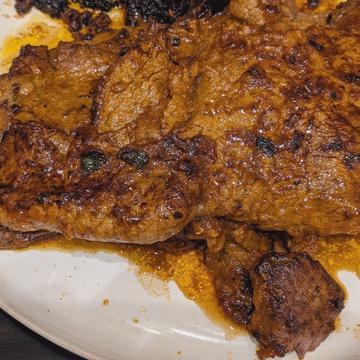 Searing the marinated beef until nicely browned and cooked through.