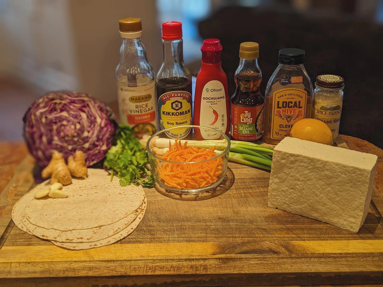 Platter of Spicy Gochujang Tofu taco ingredients on a cutting board.